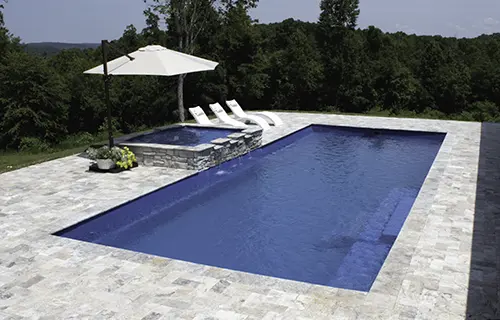 Leisure Pools The Grand rectangular fiberglass composite pool for lounging, installed by Leisure Pools Lake City